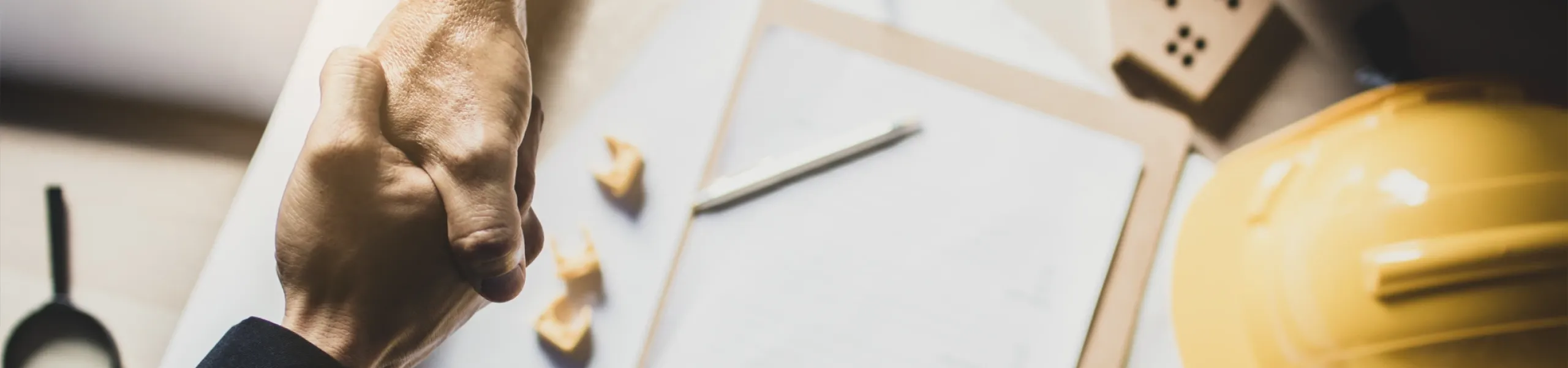 Gros plan en plongée d'un homme d'affaires et d'un architecte se serrant la main dans un bureau.